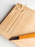 Wood carving techniques on softwood with precision knife and geometric patterns photo