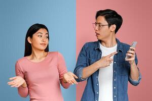 Who is this guy. Angry asian man checking his girlfriend mobile phone and asking her explanation photo