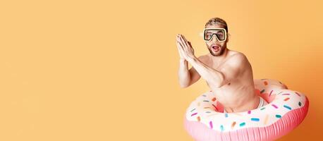 Funny guy in inflatable circle getting ready to dive, free space photo