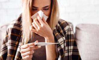 High temperature concept. Female isolation at home during coronavirus photo