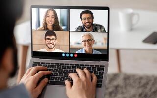 Four friends are enjoying a lively call, smiling and engaging with each other. The setting is relaxed, with a cozy background and a focus on their friendly conversation. photo