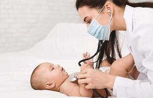 Baby is sick. Pediatrician listening to child breath, examining lungs with stethoscope, free space photo
