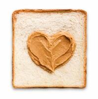 Peanut butter spread in a heart shape on a piece of toast, top view photo