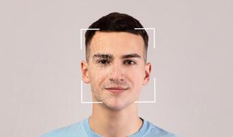 Smiling young caucasian male, double exposure with id scan, isolated on light background. Futuristic and technological face scanning for face recognition and person. Personal safety, future, security photo