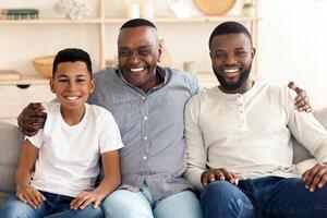 Cheerful Family Members Posing To Camera At Home, Embracing On Sofa And Smiling photo