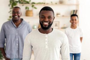 Three Generations. Smiling Black Father, Son And Grandfather Posing Standing At Home, Looking At Camera, Selective Focus On Millennial Man photo