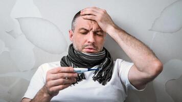 Sick Man Having Fever Measuring Temperature With Thermometer Having Flu Symptoms Lying In Bed At Home. Selective Focus photo