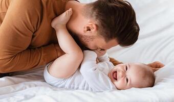 Father's Love. Dad Cuddling Bonding With Little Baby Son Spending Time Together Lying On Bed At Home. Loving Daddy Laughing Playing With Cute Toddler. Fatherhood, Parenting Joy And Child Care photo