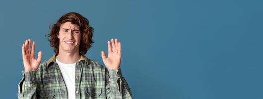 Millennial guy with disgusted face showing denial gesture on turquoise background photo