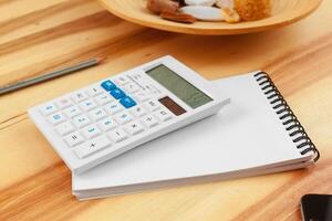 Notepad with pen and calculator on the table. photo