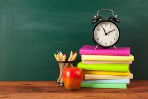 back to school - apple and books with pencils and blackboard photo