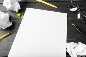 Blank notebook and pencil with glasses on wooden table photo