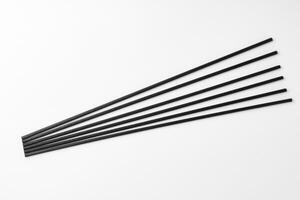 Black aromatic sticks resting on a plain white background photo