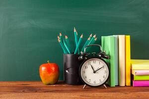 back to school - apple and books with pencils and blackboard photo