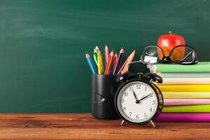 back to school - apple and books with pencils and blackboard photo