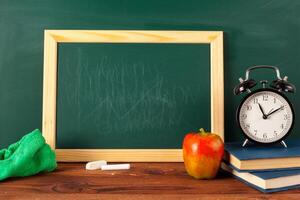 back to school - apple and books with pencils and blackboard photo