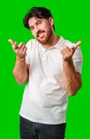 Smiling man gestures playfully with finger guns against a vibrant green background photo