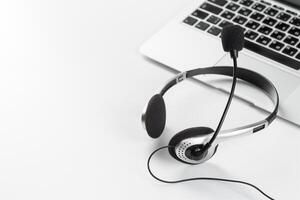 call center support concept. headset on keyboard computer laptop photo