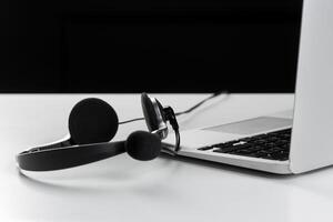 call center support concept. headset on keyboard computer laptop photo