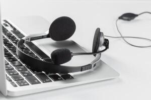 call center support concept. headset on keyboard computer laptop photo