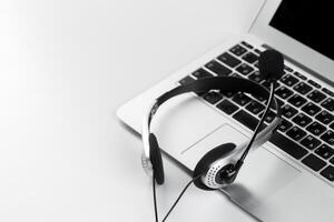 call center support concept. headset on keyboard computer laptop photo