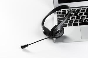 call center support concept. headset on keyboard computer laptop photo