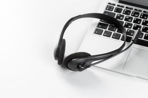 call center support concept. headset on keyboard computer laptop photo