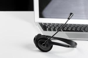 call center support concept. headset on keyboard computer laptop photo