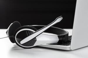 call center support concept. headset on keyboard computer laptop photo