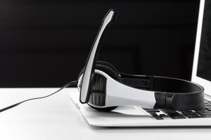call center support concept. headset on keyboard computer laptop photo