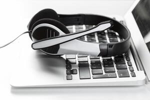call center support concept. headset on keyboard computer laptop photo
