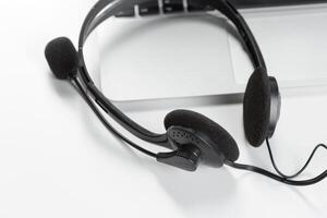 call center support concept. headset on keyboard computer laptop photo