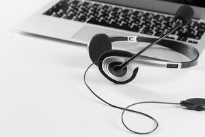 call center support concept. headset on keyboard computer laptop photo