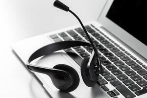 call center support concept. headset on keyboard computer laptop photo