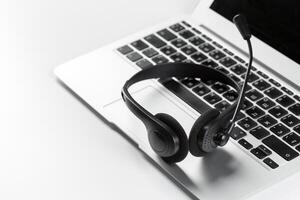 call center support concept. headset on keyboard computer laptop photo