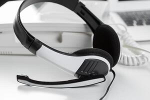 call center support concept. headset on keyboard computer laptop photo