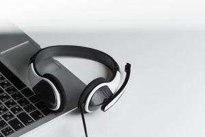 call center support concept. headset on keyboard computer laptop photo