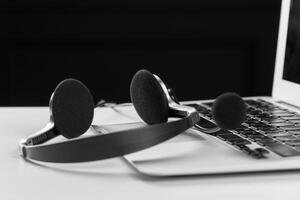 call center support concept. headset on keyboard computer laptop photo