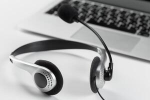 call center support concept. headset on keyboard computer laptop photo
