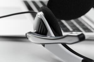 call center support concept. headset on keyboard computer laptop photo