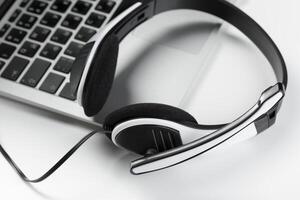 call center support concept. headset on keyboard computer laptop photo