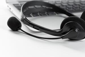 call center support concept. headset on keyboard computer laptop photo