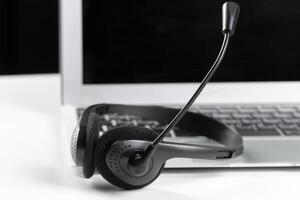 call center support concept. headset on keyboard computer laptop photo