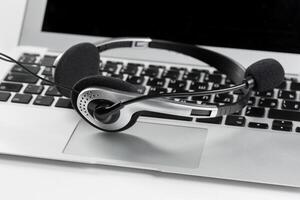 call center support concept. headset on keyboard computer laptop photo