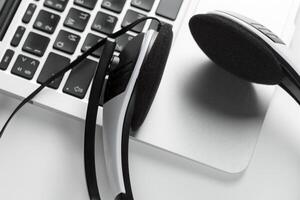 call center support concept. headset on keyboard computer laptop photo