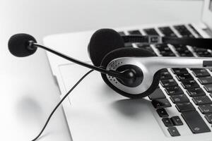 call center support concept. headset on keyboard computer laptop photo