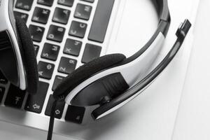 call center support concept. headset on keyboard computer laptop photo