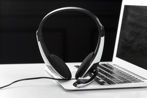 call center support concept. headset on keyboard computer laptop photo