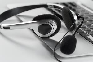 call center support concept. headset on keyboard computer laptop photo