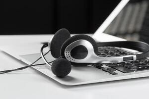 call center support concept. headset on keyboard computer laptop photo